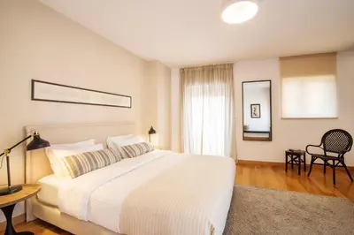 a white bedroom with a large bed and a desk at Villa Amaryllis in Athens