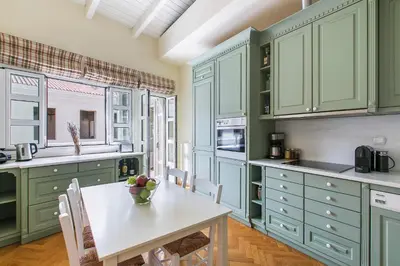 a kitchen with green cabinets and a table with a bowl of fruit on it at Aerides 3 Luxury Suites in Athens