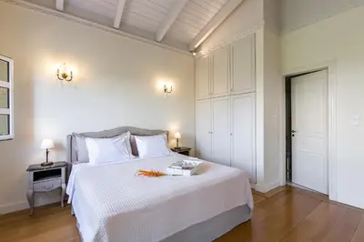 a bedroom with a white bed with two tables and two lamps at Aerides 3 Luxury Suites in Athens