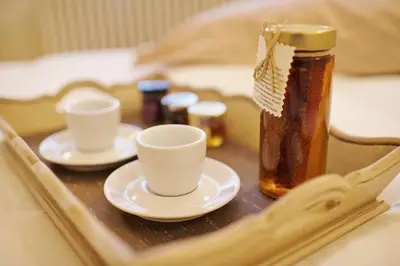 a tray with two cups and a bottle of honey at Aerides 3 Luxury Suites in Athens