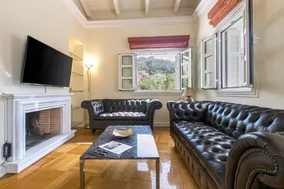 a living room with a leather couch and a fireplace at Aerides 3 Luxury Suites in Athens