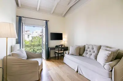 a living room with a white couch and a television at Aerides 3 Luxury Suites in Athens