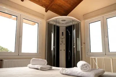 a bedroom with two towels on a bed with windows at Casa Saronida in Lagonissi