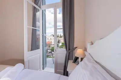 a bedroom with a bed and a door to a balcony at Palladian Home in Athens