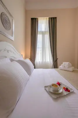 a white bed with a plate with a cup of coffee on it at Palladian Home in Athens