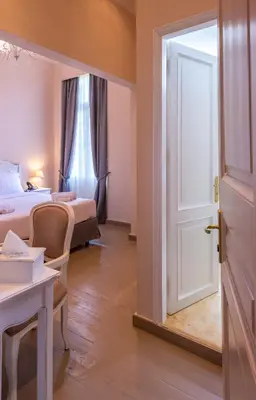a room with a bed and a desk and a door at Palladian Home in Athens