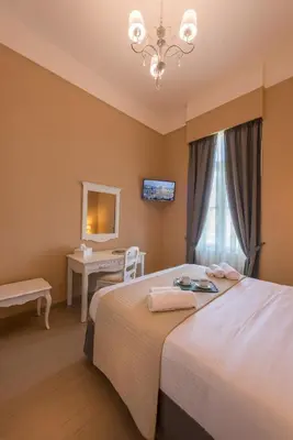 a bedroom with a bed with a desk and a window at Palladian Home in Athens