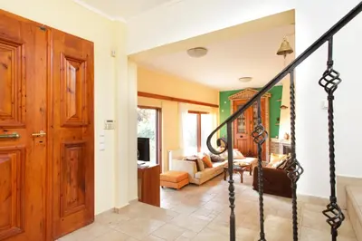 a hallway with a staircase and a living room at Villa Soula in Anavissos
