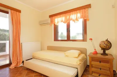 a bedroom with a bed and a window at Villa Soula in Anavissos