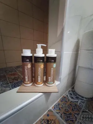 two bottles ofodorizers sitting on a shelf in a bathroom at Ermou & Athinas Suites in Monastiraki in Athens