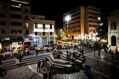 a group of people walking around a city at night at Ermou & Athinas Suites in Monastiraki in Athens