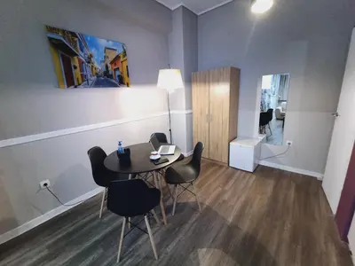 a dining room with a table and chairs in a room at Ermou & Athinas Suites in Monastiraki in Athens