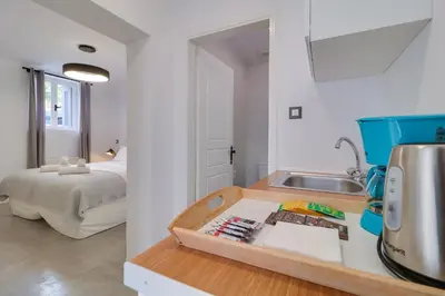 a kitchen with a counter with a sink and a bed at Athens Residence Apartments in Athens