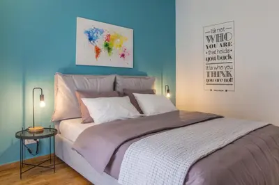 a bedroom with a large bed with a blue wall at The Athens Insider in Athens