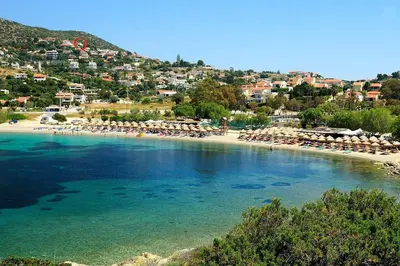 a beach with a bunch of umbrellas and chairs at Seaview near Athens & Sounio in Anavissos