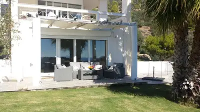 a white house with a patio and a lawn at Seaview near Athens & Sounio in Anavissos