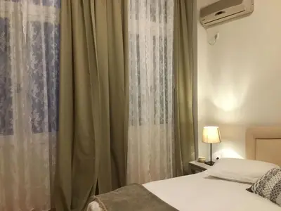 a bedroom with a bed and a window with curtains at Athens-Plaka, Peter's House in Athens