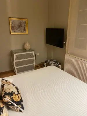 a bedroom with a bed and a flat screen tv at Athens-Plaka, Peter's House in Athens