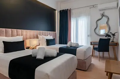 a hotel room with two beds and a desk at Acropolis View Deluxe Penthouse & Luxury Apartments in Athens