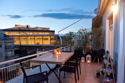 a patio with a table and chairs on a balcony at Acropolis View Deluxe Penthouse & Luxury Apartments in Athens