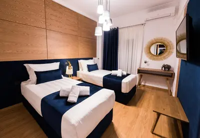 a hotel room with two beds and a table at Acropolis View Deluxe Penthouse & Luxury Apartments in Athens