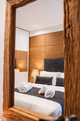 a mirror reflecting a bed with towels on it at Acropolis View Deluxe Penthouse & Luxury Apartments in Athens