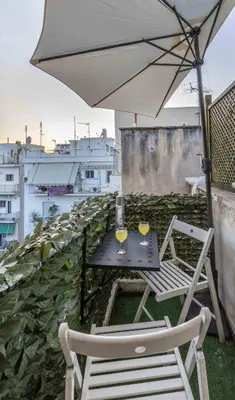 a table with two chairs and an umbrella on a balcony at Central 6th Floor Studio Near Metro & View&200mbps in Athens
