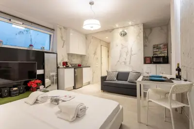 a living room with a couch and a table with chairs at Stadium HiEnd Studio Top Location in Athens