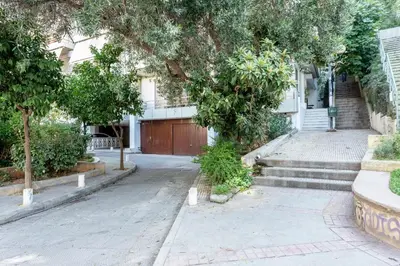 a house with a gate and stairs and trees at Stadium HiEnd Studio Top Location in Athens