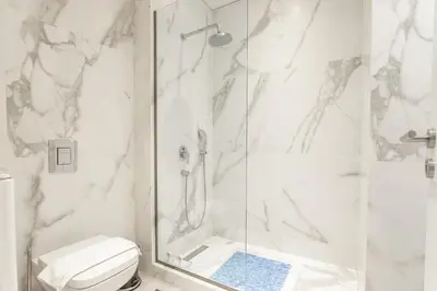 a white bathroom with a shower and a toilet at Stadium HiEnd Studio Top Location in Athens