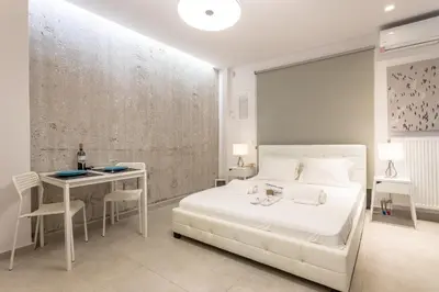 a white bedroom with a white bed and a table at Stadium HiEnd Studio Top Location in Athens