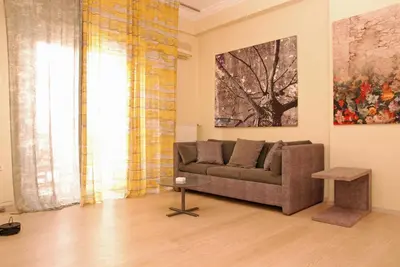 a living room with a couch and a painting at Acropolis View Luxury Suite in Athens