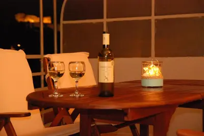 a bottle of wine and two glasses on a wooden table at Acropolis View Luxury Suite in Athens