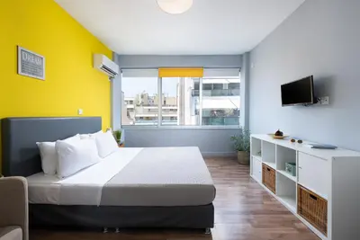 a bedroom with a bed and a yellow wall at Enattica Syntagma Living in Athens