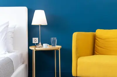 a side table with a lamp and a yellow chair at Enattica Syntagma Living in Athens