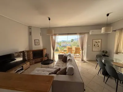 a living room with a couch and a table at Anavyssos Garden House in Palaiá Fókaia