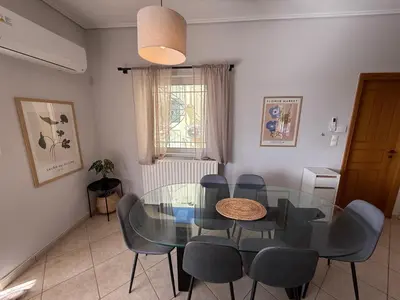 a dining room with a glass table and chairs at Anavyssos Garden House in Palaiá Fókaia