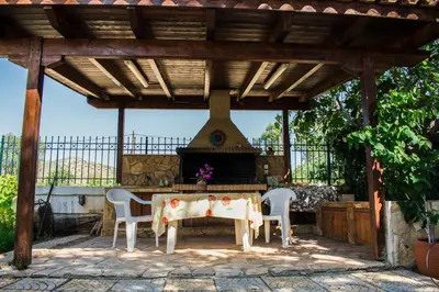 a patio with a table and chairs under a pergola at Anavyssos Garden House in Palaiá Fókaia