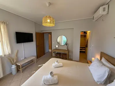 a bedroom with a large bed with towels on it at Anavyssos Garden House in Palaiá Fókaia