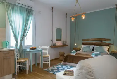 a bedroom with a bed and a table and a desk at Athens Wooden Studio in Athens