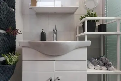 a bathroom with a white sink and shelves at Athens Wooden Studio in Athens