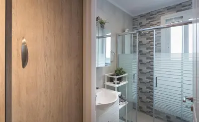 a bathroom with a sink and a glass shower at Athens Wooden Studio in Athens