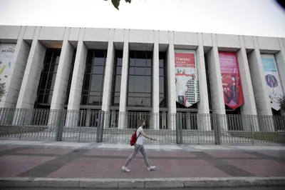 a woman walking in front of a building at Athens Wooden Studio in Athens