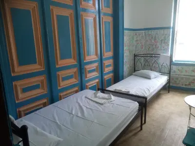 two beds in a room with blue walls at Sparti in Piraeus