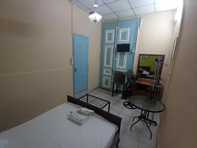 a room with a bed and a table and a door at Sparti in Piraeus