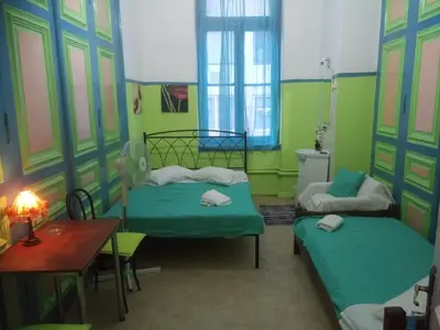 a room with two beds and a table in it at Sparti in Piraeus