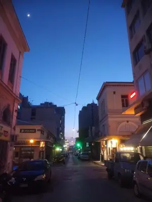a city street at night with cars parked on the street at Sparti in Piraeus