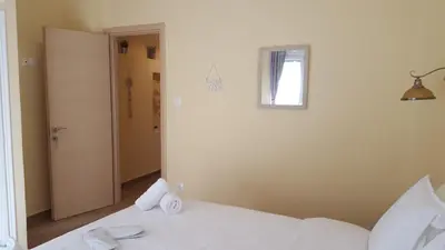 a bedroom with a white bed and a mirror at Zoe's Studio in Athens
