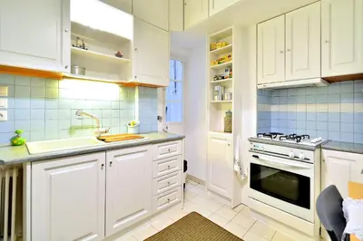 a kitchen with white cabinets and a sink and a stove at Plaka Elegant Apartment in Athens