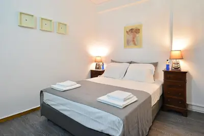 a bedroom with a bed with two night stands and two lamps at Plaka Elegant Apartment in Athens
